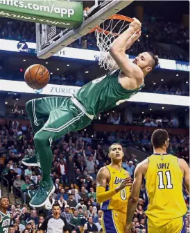  ?? — AP ?? Going for more: Boston Celtics’ Aron Baynes hanging from the rim after dunking during the fourth quarter of Boston’s 107-96 win over the Los Angeles Lakers in an NBA game on Wednesday.