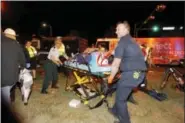  ?? SCOTT THRELKELD — THE ADVOCATE VIA AP ?? New Orleans emergency personnel attend to an injured parade watcher after a pickup truck plowed into a crowd injuring multiple people watching the Krewe of Endymion parade in the Mid-City section of New Orleans, Saturday. Police Chief Michael Harrison...