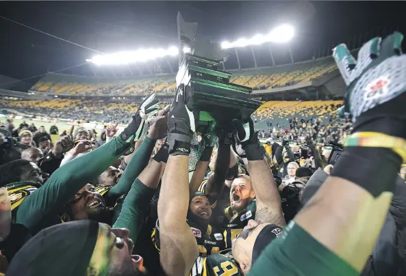  ?? ED KAISER/EDMONTON JOURNAL ?? The Edmonton Eskimos celebrate with the trophy after defeating the Calgary Stampeders 45-31 Sunday during the CFL Western Final in Edmonton.