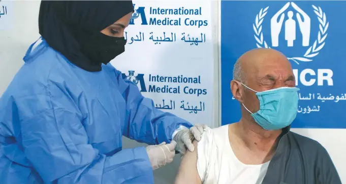  ?? / AFP ?? Un refugiado sirio recibe la vacuna contra el COVID-19 en Jordania, país que recibió a más de 1,3 millones de personas que huyeron de la guerra en Siria.