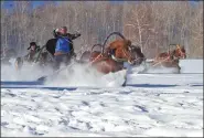  ??  ?? Ethnic Kazak people compete in a horse-drawn sleigh competitio­n.
