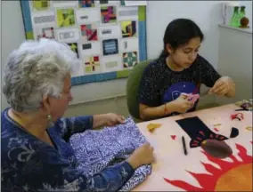  ?? SOCIAL JUSTICE SEWING ACADEMY VIA AP ?? This photo provided by the Social Justice Sewing Academy shows Yesenia Madrid creating a social justice art quilt with the help of SJSA Volunteer, Lynn Hickman at Bay Quilts in Richmond