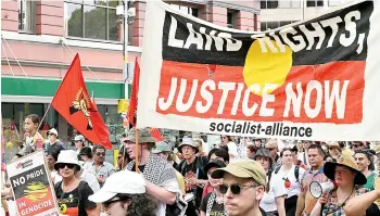  ?? — AFP photo ?? Protesters with signs and placards march during the annual ‘Invasion Day’ protest march through the streets of Sydney on Australia Day.