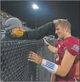  ??  ?? El Modena quarterbac­k Jackson Keays (right) is congratula­ted by his father, Joe, after the team’s 42-20 win against El Dorado. “We had to keep staying positive and keep believing there is going to be an opportunit­y to have a football season,” Joe Keays said. “Thank God it came through.”