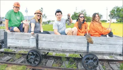  ?? SHARON MONTGOMERY-DUPE/CAPE BRETON POST ?? Coal Dust Days chair Jim MacKinnon, from left, has a little fun in a coal cart at Collieryla­nds Park in New Waterford with the Coal Dust Days summer students Morgan Donohue, Joey Lever, co-ordinator, Rebecca Antle and Larissa LeBlanc.