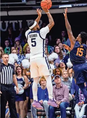  ?? MICHELLE PEMBERTON/INDYSTAR ?? Butler guard Posh Alexander (5) shoots past California guard Jalen Cone (15) during a game on Saturday at Hinkle Fieldhouse. The Bulldogs rallied from an early 18-4 deficit.