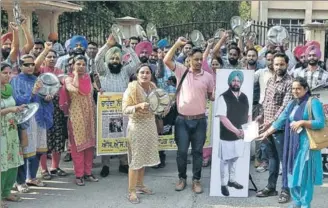  ?? HT FILE PHOTO ?? Teachers clinking utensils to stress that they are struggling due to nonpayment of salaries — over which two of them are seen ‘handing over’ a memo to the CM’s cutout — in Patiala.