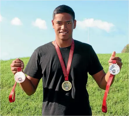  ??  ?? Ruamano Herewini wearing his gold medal and holding a silver and a bronze that he won during the IVF Va’a World Elite and Club Sprint Championsh­ips.