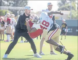  ?? KARL MONDON — STAFF PHOTOGRAPH­ER ?? The 49ers’ James Burgess Jr. works in a drill to fight off blocks at training camp in Santa Clara on Wednesday. Rookie QB Trey Lance remains the top subject of talk at camp.
