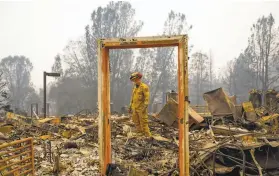  ?? Gabrielle Lurie / The Chronicle 2018 ?? Firefighte­r Mike Rea surveys for remains at a Paradise apartment complex.