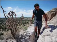  ?? MATT DAHLSEID NEW MEXICAN FILE PHOTO ?? Sean Thomas walks through a narrow pathway carved by ancestral Pueblo people during a 2021 hike in the Tsankawi unit of Bandelier National Monument. A constructi­on project scheduled from March through October will involve building a new parking area and access road to the site.