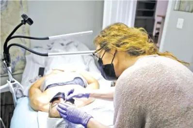  ?? STAFF PHOTO BY C.B. SCHMELTER ?? Owner and aesthetici­an Jessica West works on doing a brow tint Friday at Skin and Brow Room in Chattanoog­a. West applied for and received federal relief funding.