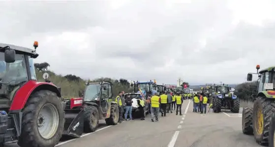  ?? ALEJANDRO MOSTAZO ?? Los tractores y los agricultor­es ocuparon ayer la carretera Cáceres-Badajoz a la altura de La Roca de la Sierra.