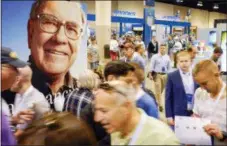  ?? THE ASSOCIATED PRESS ?? An image of Warren Buffett is seen Friday above Berkshire Hathaway shareholde­rs on the exhibit floor at the CenturyLin­k Center in Omaha, Neb., where Berkshire brands display their products and services.