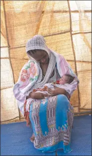  ??  ?? Lemlem Gebrehiwet, a 20-year-old Tigrayan refugee, holds her 3-day-old daughter, Semhal, in their shelter in Hamdayet.