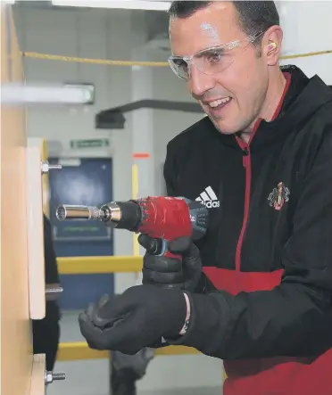  ??  ?? Sunderland defender John O’Shea gets down to work at Peterlee’s Caterpilla­r plant. Pictures by Ian Horrocks