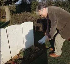  ??  ?? Gerry Waldron sprinkles some Tralee soil of the grave of ‘Thady’ O’Connor who was killed on November 4, 1918, one week before the signing of the Armistice and the end of the First World War.