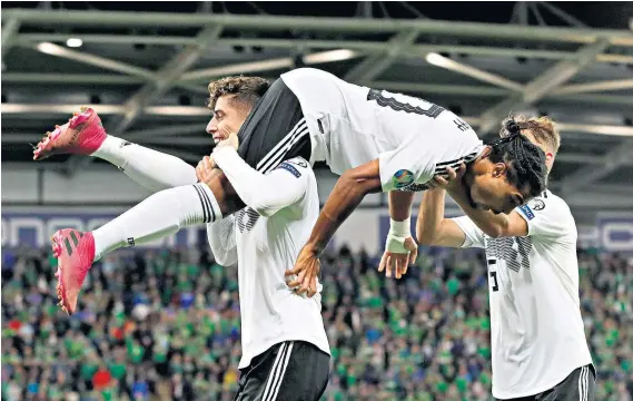  ??  ?? Flying high: Serge Gnabry is hoisted into the air after sealing Germany’s victory by scoring their 90th-minute second goal last night