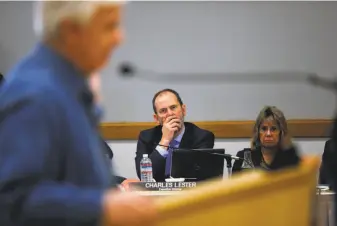  ??  ?? Sonoma County Supervisor Efren Carrillo (right), before a Coastal Commission meeting in Morro Bay, protests the firing of Executive Director Charles Lester. Steve Ray (left) addresses members of the state Coastal Commission on Wednesday as Lester (center) listens. At the meeting, the commission­ers fired Lester, who was in charge since 2011.