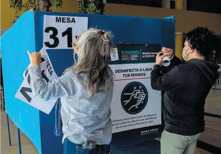  ?? MARTIN BERNETTI / AFP ?? Disputa. Seção eleitoral é preparada em escola de Santiago; votação ocorrerá em dois dias por causa da pandemia