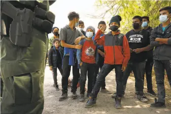  ?? Carolyn Cole / Los Angeles Times ?? Juvenile migrants board a bus in March to be taken to a Border Patrol facility in La Joya, Texas. More than 18,700 unaccompan­ied children and teenagers were taken into custody last month.