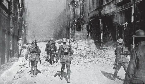  ??  ?? Rapid advance: Our soldiers walk along a rubble-strewn boulevard in Cambrai following the enemy retreat