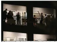  ?? (AP/Missourian/Dan Shular) ?? Partiers congregate on the balcony of an apartment in downtown Columbia, Mo., near the University of Missouri campus. As cases spike in college towns, bars have been shut down and students, fraterniti­es and sororities have faced discipline for parties and large events.