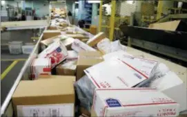  ?? NATI HARNIK — THE ASSOCIATED PRESS FILE ?? Packages travel on a conveyor belt for sorting at the main post office in Omaha, Neb. States will be able to force shoppers to pay sales tax when they make online purchases under a Supreme Court decision Thursday that will leave shoppers with lighter...