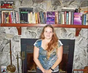  ?? PHOTO SPECIAL TO THE DISPATCH BY MIKE JAQUAYS ?? Durhamvill­e-based author Almondie Shampine poses with just a few of the hundreds of her books at her home on Aug. 3. That collection includes not only hundreds of favorites but several of her own as well, and she will discuss her novels this Thursday...