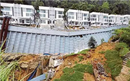  ?? PIC BY RAMDZAN MASIAM ?? A landslide and sinkhole caused the two-lane road in front of a row of newly-built luxury homes in Jalan Persiaran Tanjung Bungah 3 to collapse yesterday.