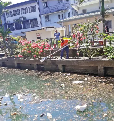  ?? Photo: Shalveen Chand ?? Suva City Council workers busy picking rubbish from Nubukalou Creek in the Central Business District.