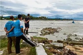  ??  ?? Sunken vessel: Locals looking at a sunken fishing boat because of bad weather due to tropical storm Pabuk in the southern Thai province of Narathiwat.