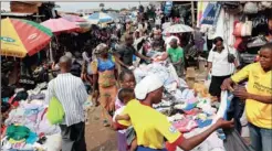  ??  ?? Prospectiv­e customers browse the selection of second-hand clothes at Katangua market in Lagos, Nigeria. Shipping containers arrive at this market filled to the brim with bales of secondhand clothes from the US and elsewhere. Traders scour, barter, hem...