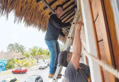  ?? REUTERS ?? Habitantes de Oaxaca protegen sus casas y negocios previo al impacto del huracán