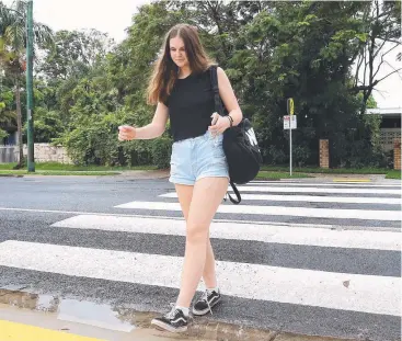  ?? Picture: STEWART McLEAN ?? SAFE OPTION: Lily Pankhurst uses the pedestrian crossing along Oleander St near Hickory St that has been returned by Cairns Regional Council after it was removed.