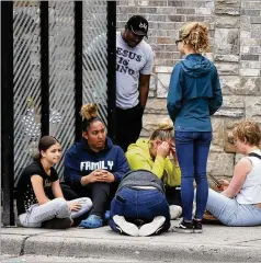  ?? JIM MONE / ASSOCIATED PRESS ?? Mourners gather Tuesday around a memorial in Minneapoli­s near where a black man was taken into police custody and died.