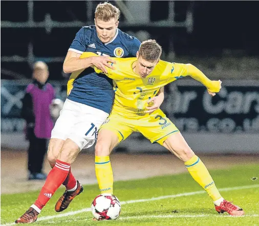  ??  ?? HOLD ON, THERE: Scotland’s Chris Cadden, left, gets to grips with Ukraine’s Mykola Matviyenko