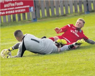  ?? FJA Photograph­y/Paul Watson ?? Runcorn Town midfielder Paul McManus makes a sliding challenge for the ball as Barnoldswi­ck Town goalkeeper Ryan Livesey attempts to get his hands on it during the teams’ clash at the Silentnigh­t Stadium.