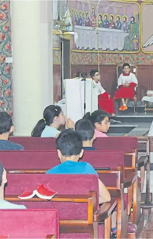  ??  ?? En acción. El padre Gabriel imparte catequésis a los niños que se preparan para l