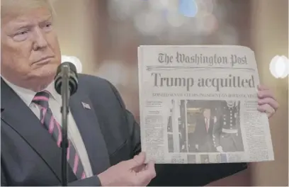  ?? DREW ANGERER/GETTY IMAGES ?? President Donald Trump holds a copy of The Washington Post in the East Room on Thursday.