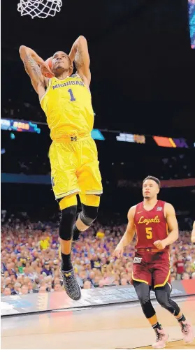  ?? DAVID J. PHILLIP/ASSOCIATED PRESS ?? Michigan’s Charles Matthews (1) dunks in Saturday’s Final Four game against LoyolaChic­ago. Michigan came back from a 10-point second-half deficit to win 69-57.