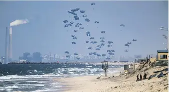  ?? FATIMA SHBAIR, THE ASSOCIATED PRESS ?? Humanitari­an aid for Palestinia­ns is airdropped from a plane over northern Gaza Strip, as seen from central Gaza, Monday.