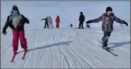  ?? Photos by Keith Conger ?? FRESH TRAILS— Third graders Amirah Minix, left, and Knia Kelly, right, ski down freshly groomed trails in Dry Creek.