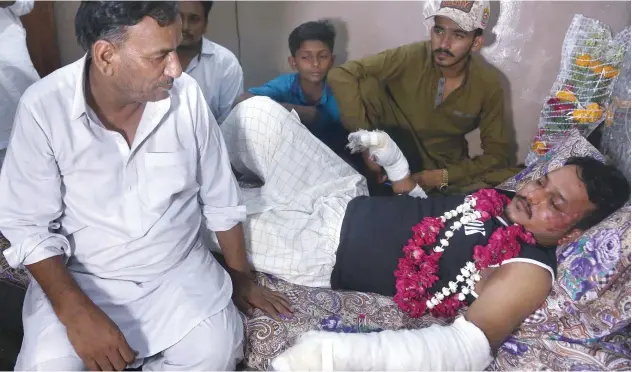  ?? Associated Press ?? ↑ Relatives visit Mohammad Zubair, a passenger who survived the plane crash, at his home in Karachi on Saturday.