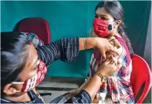  ??  ?? A medic administer­s a dose of the COVID-19 vaccine to a woman, at a centre in Kolkata, on Thursday