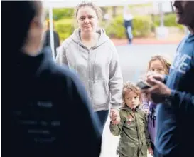  ?? GREGORY BULL/AP ?? A Ukrainian family arrives Friday at the Christian church Calvary San Diego shelter for refugees in Chula Vista, Calif., after crossing from Tijuana, Mexico, into the U.S.