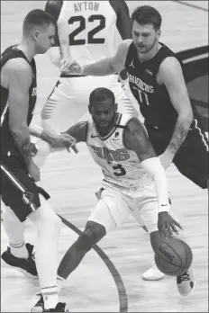  ?? ASSOCIATED PRESS ?? DALLAS MAVERICKS FORWARD KRISTAPS PORZINGIS (left) and guard Luka Doncic (77) defend against Phoenix Suns guard Chris Paul (3) in the first half during a game on Monday in Dallas.