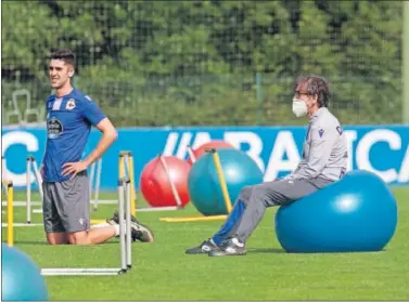  ??  ?? Sabin Merino, del Deportivo, se ejercita ante la atenta mirada de Fernando Vázquez.