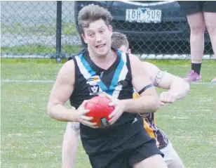  ??  ?? Yarragon’s Jake Borsato breaks away from his Morwell East opponent; Photograph­s: Michael Robinson.