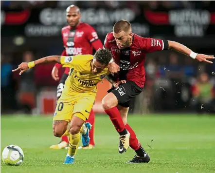  ?? — Reuters ?? Holding his ground: Paris St Germain’s Neymar staves off a challenge from Guingamp’s Lucas Deaux on Sunday.